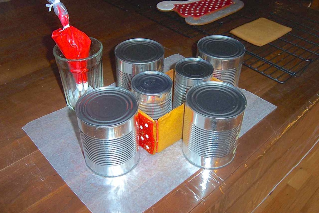 Side view of the cans holding up and holding together the glued sides of the sleigh "box" for drying.