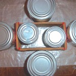Showing aluminum cans holding the glued sides of box in place for drying.