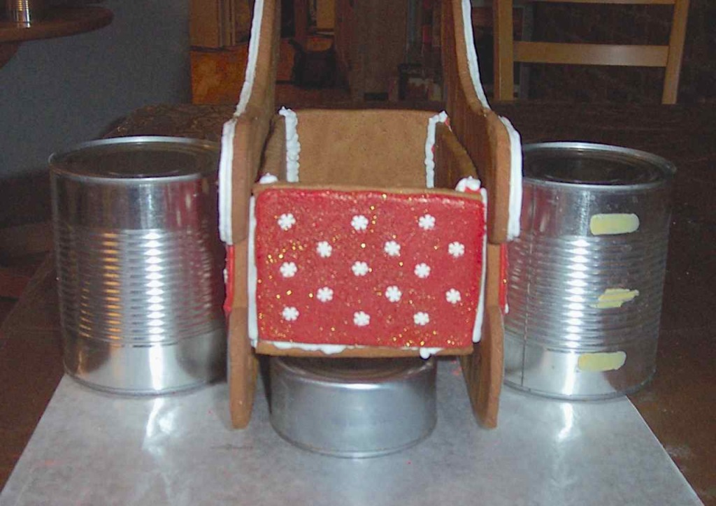 Front view of sleigh with box glued in and supported by cans while drying. A tuna can holds up the box on the bottom.
