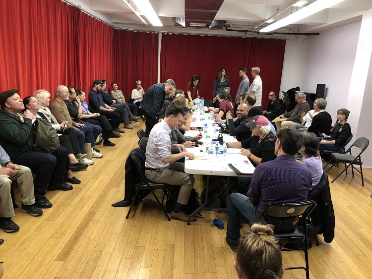 actors around a table in a room, reading script