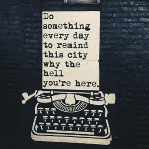 typewriter illustration against brick wall